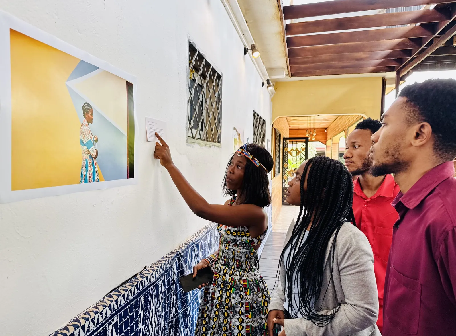 Visitors looking at a photograph on the wall of the exhibition at Au Comptoir des Arts