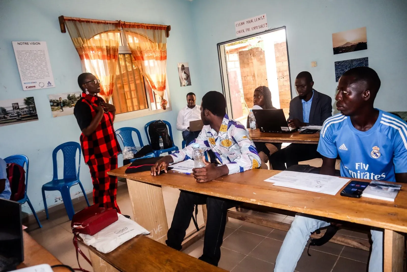 Adults seated at tables during a BRIGHT session, a facilitator standing by the window